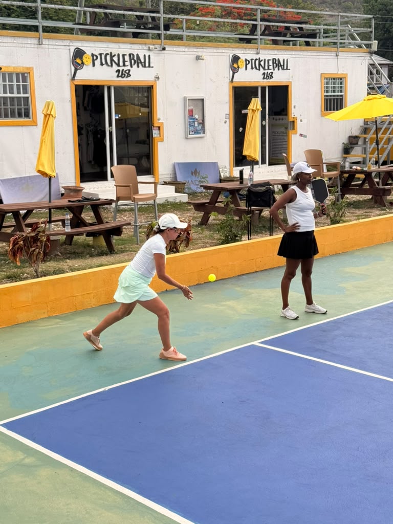 Player chasing down a low ball near the clubhouse courts