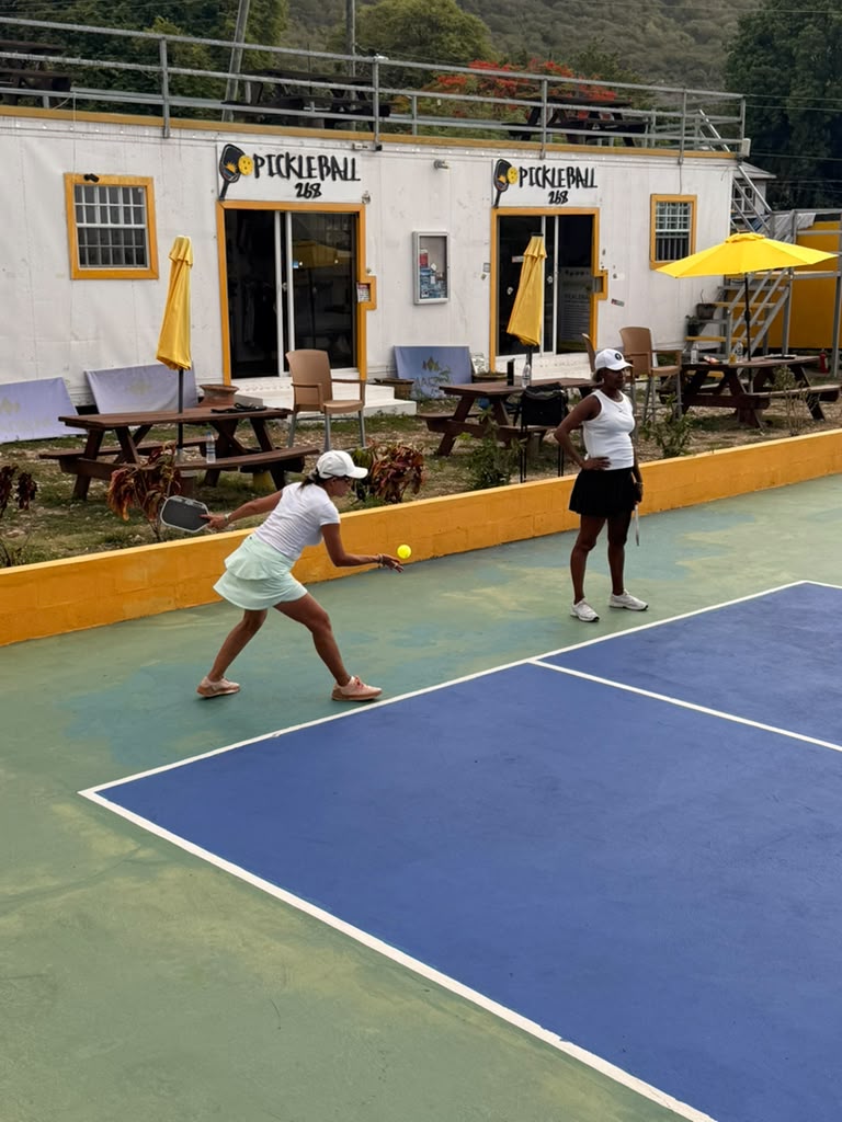 Player lunging low to return a ball just above the court surface