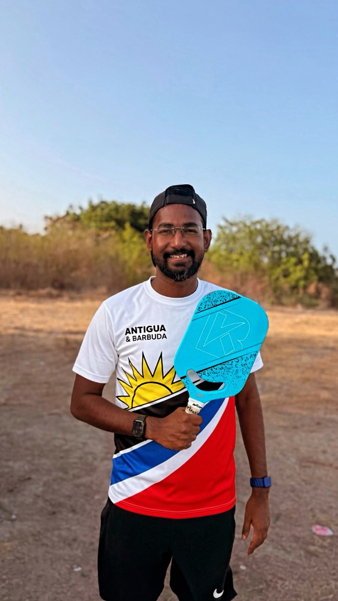 Player in an Antigua and Barbuda jersey holding a teal paddle