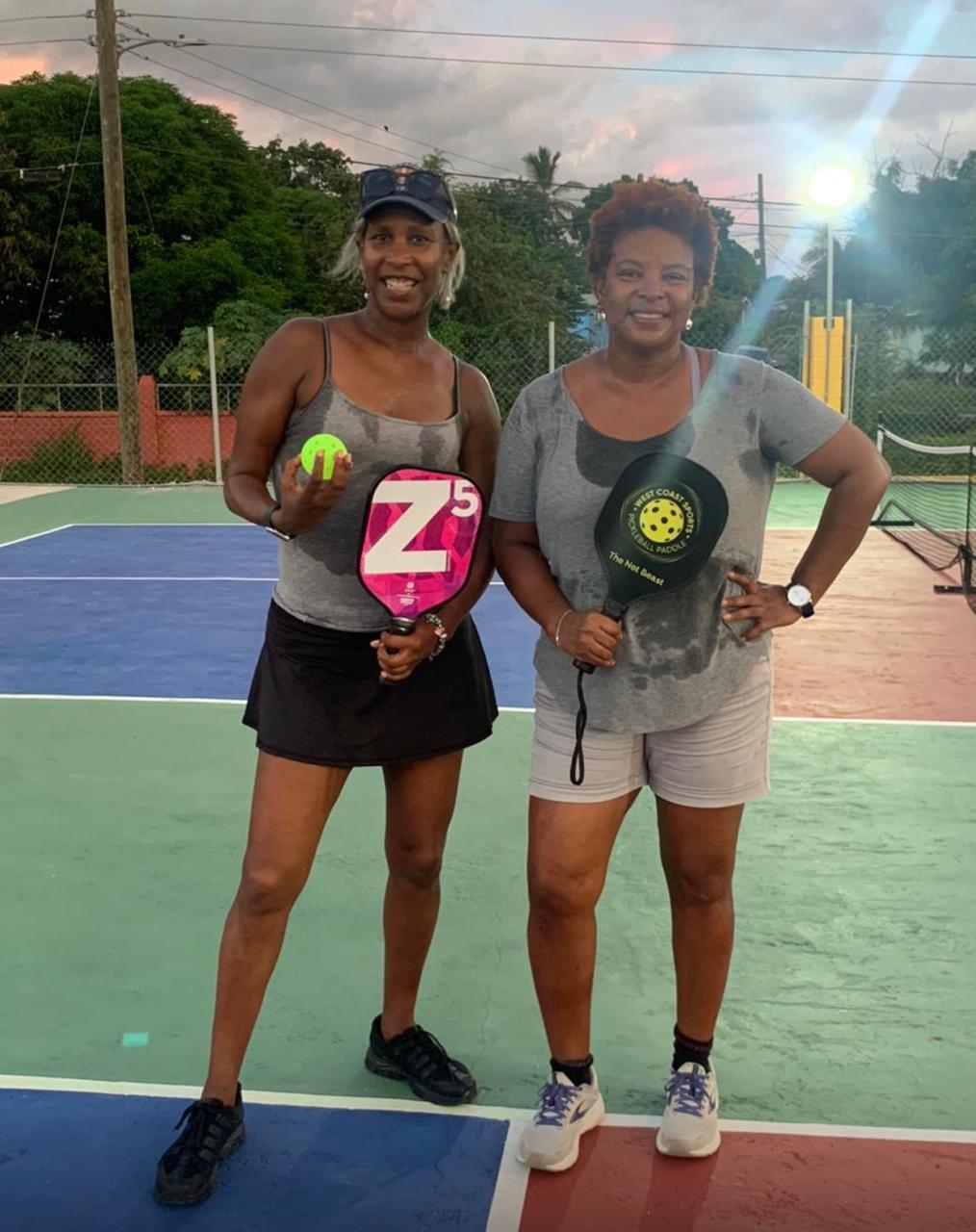 Two players holding paddles, one labelled "The Not Beast", posing on court