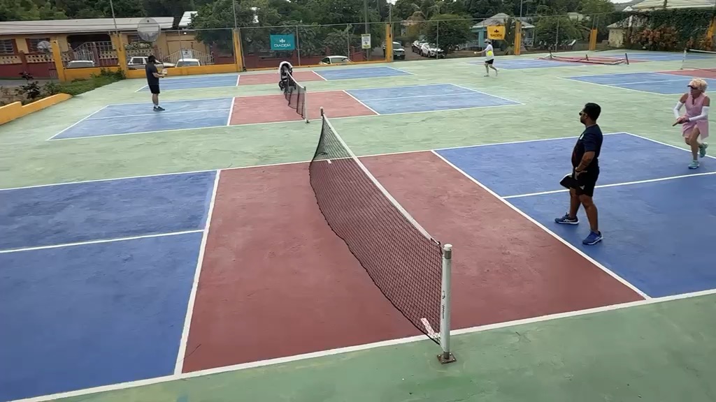 Players walking between courts during a changeover on the multi-court complex