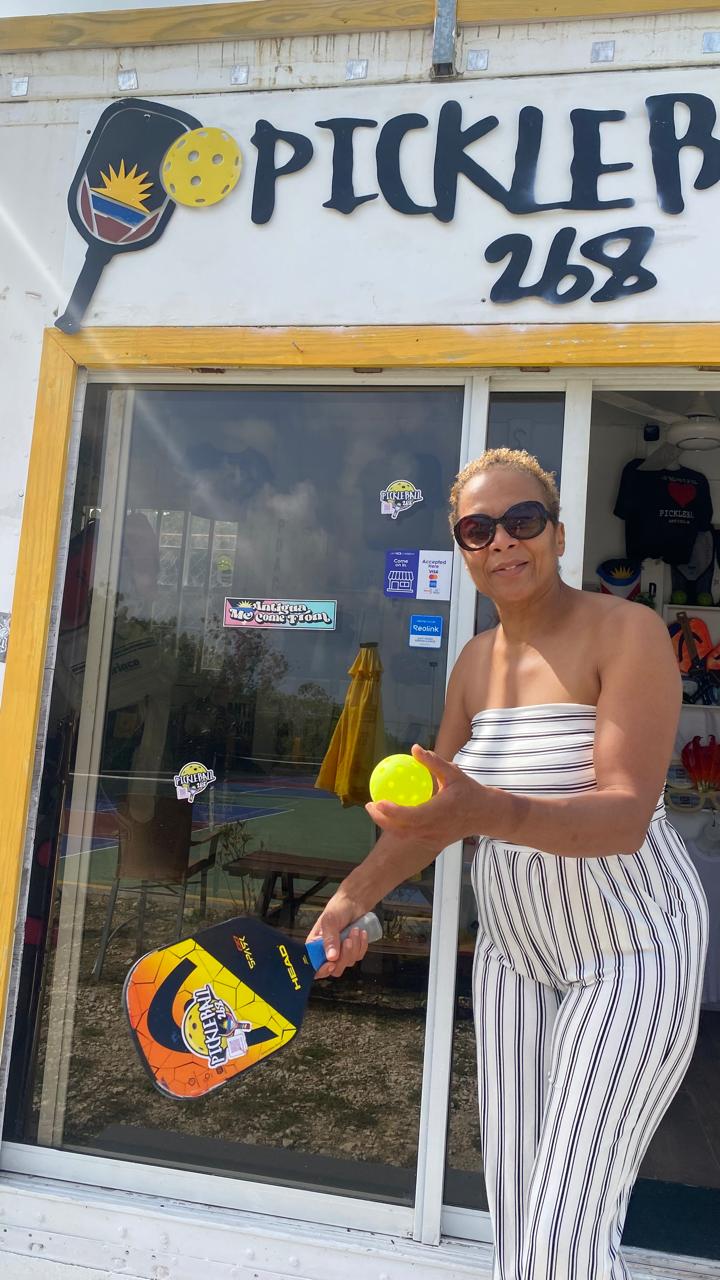 Player posing with a paddle and ball outside the Pickleball268 pro shop doorway