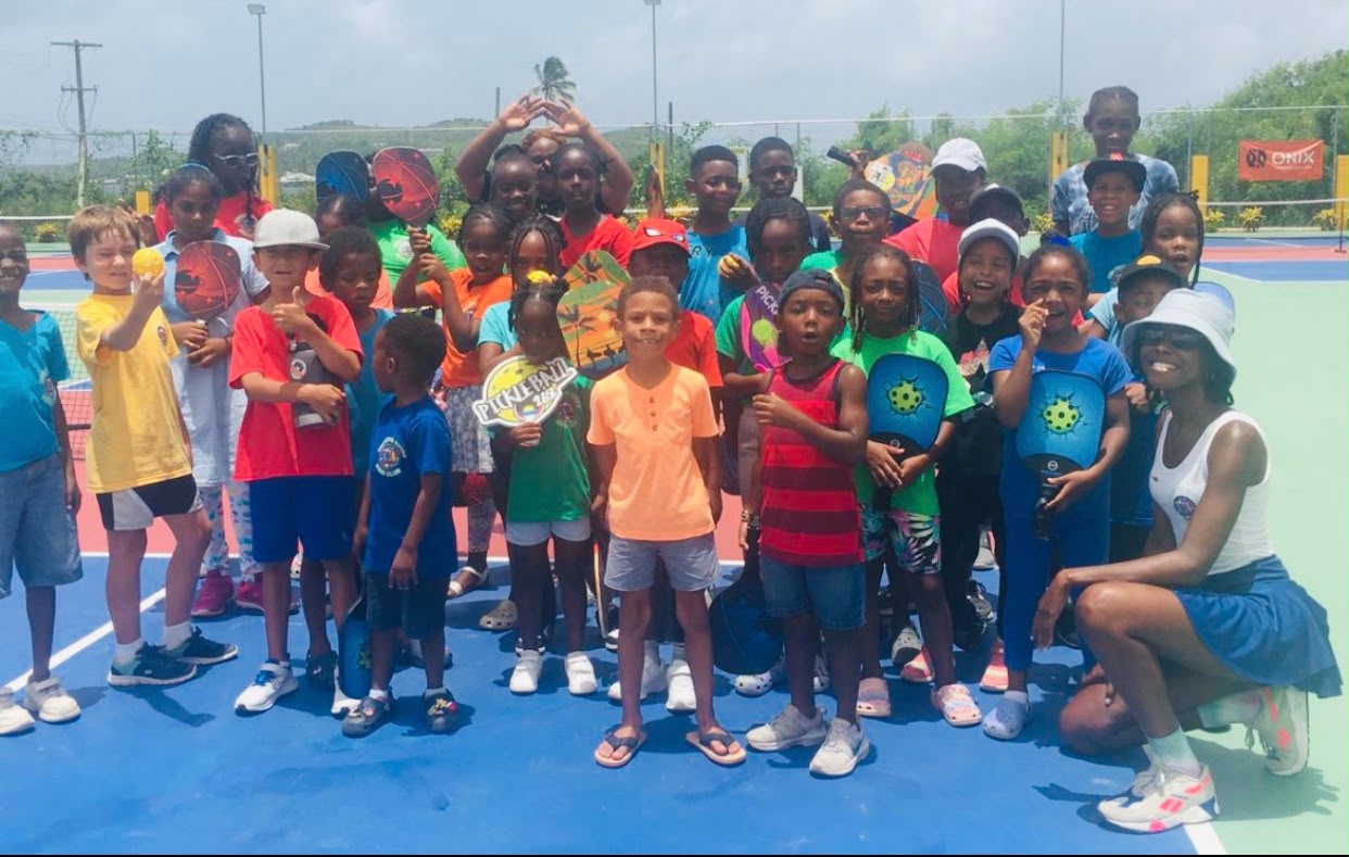 Large group of children posing with paddles at a summer pickleball camp