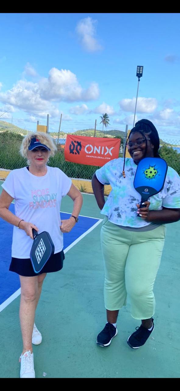 Two players posing courtside, one wearing a "More Sunday Fundays" t-shirt, next to an ONIX banner