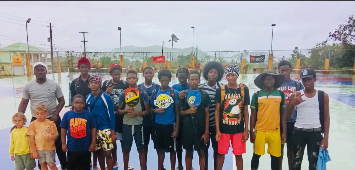 Group of teenage players posing on court in the rain