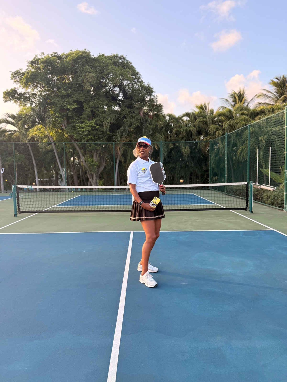 Player posing courtside with a paddle at The Verandah resort courts